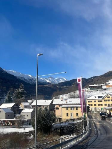 eine Stadt mit Straßenlaternen, Gebäuden und Bergen in der Unterkunft Casa Pesa - Olivone in Olivone