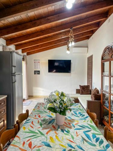 a kitchen with a table with a vase of flowers on it at Casa Gli Allori in Iglesias