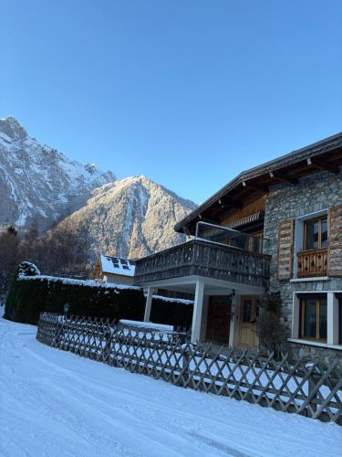 a building in the snow with mountains in the background at Chalet d'Honneur in Chamonix