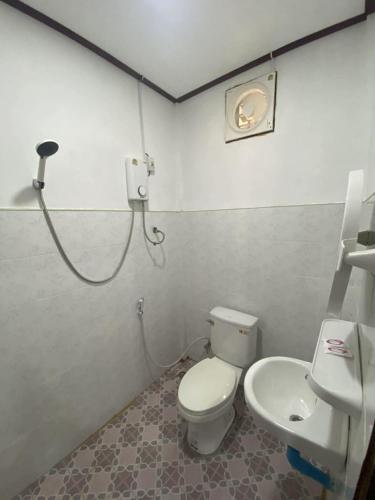 a bathroom with a toilet and a sink at Guesthouse and Restaurant SayLomYen KongLor in Ban Dôn