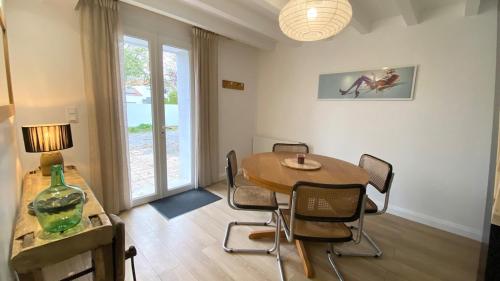 een eetkamer met een tafel en stoelen en een raam bij Maisonnette duplex in Bouguenais