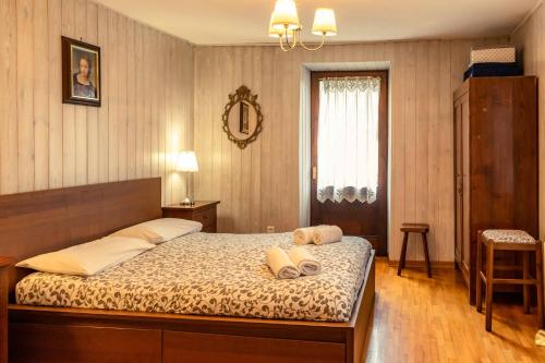 una camera da letto con un letto con due asciugamani sopra di Casa tipica nelle Dolomiti Trentine a Mezzano