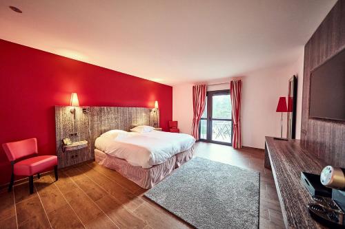 a red bedroom with a bed and a red wall at Les Maritonnes Parc & Vignoble in Romanèche-Thorins