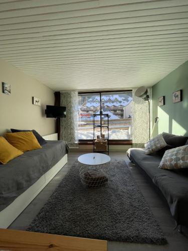 a living room with a couch and a coffee table at Studio Buron des Gardes in Le Lioran