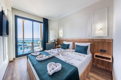 a bedroom with a large bed with a large window at Eflina Resort Hotel&Spa in Alanya
