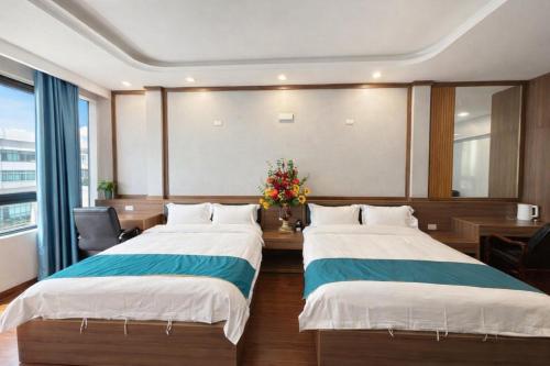 1 Schlafzimmer mit 2 Betten und einem Schreibtisch mit Blumen in der Unterkunft Phương Anh Villa Pro in Bắc Ninh