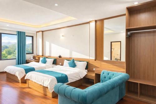 a bedroom with two beds and a blue couch at Phương Anh Villa Pro in Bắc Ninh