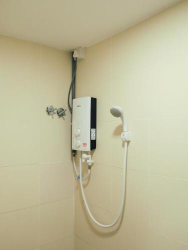 a shower in a bathroom with a hand dryer on the wall at BIG TREE HOTEL in Temerloh