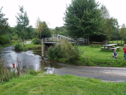 two children standing next to a river with a bridge at The White Horse Inn, Clun in Clun
