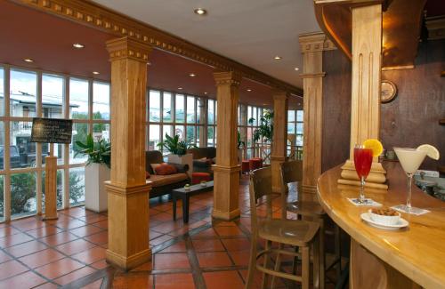 un vestíbulo con columnas y un bar en un restaurante en Del Bosque Apart Hotel en Ushuaia