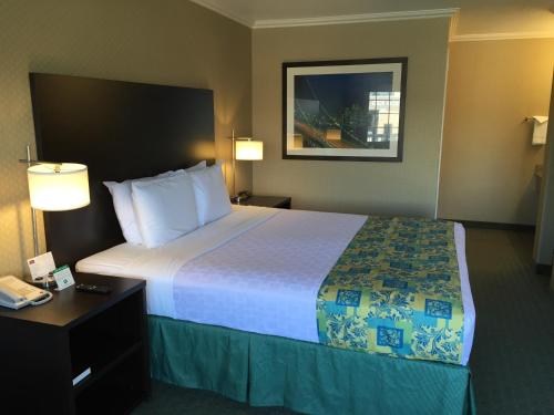 a hotel room with two beds and a television at Regency Inn at San Francisco Airport in San Bruno
