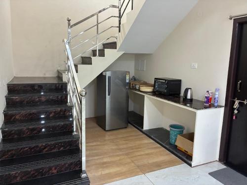 a kitchen with stairs and a refrigerator in a room at V guesthouse staycation in Bāpatla