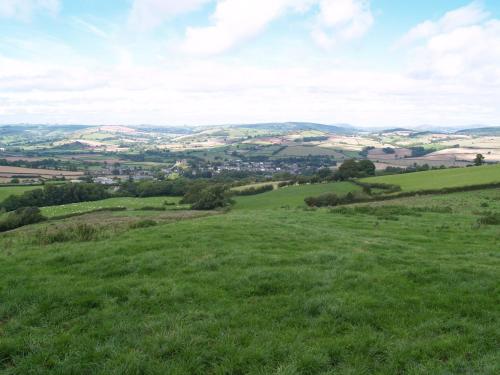 a green hillside with a city in the distance at The White Horse Inn, Clun in Clun