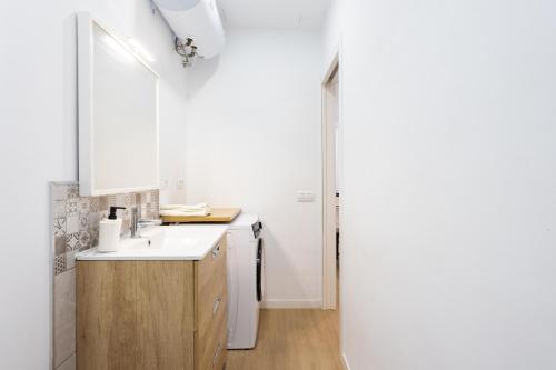 a white bathroom with a sink and a mirror at Apartamento Retama Laguna Centro in Las Lagunas