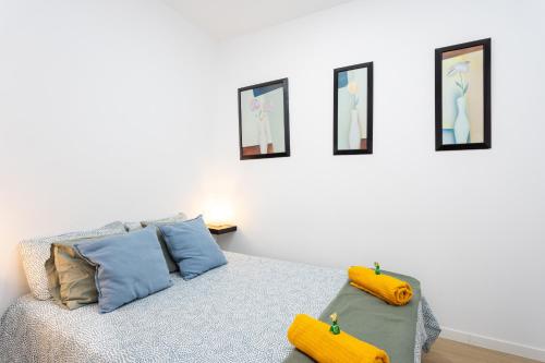 a bedroom with a bed with blue and yellow pillows at Apartamento Retama Laguna Centro in Las Lagunas