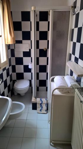 a bathroom with a black and white checkered wall at DoMarie in Venice