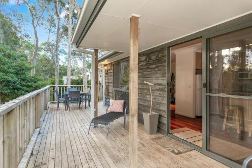 a deck with chairs and tables on a house at Bawley retreat in Bawley Point