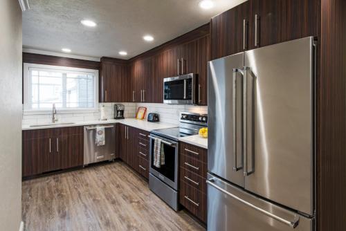 a kitchen with wooden cabinets and a stainless steel refrigerator at Beach Drive Suites in Seaside