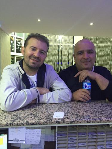 two men sitting at a table with a drink at Hotel Dosco in Van