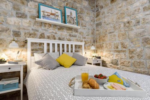 a bedroom with a bed with a tray of food on it at Apartment Fabijanko OldTown in Trogir