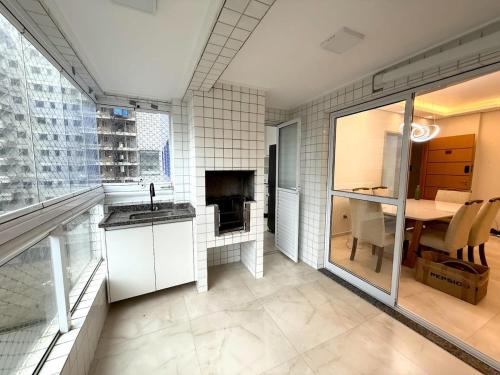 une cuisine avec un évier et une table dans une pièce dans l'établissement Apartmento com 3 dorm no Canto do Forte, à Praia Grande