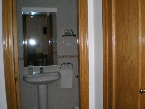 y baño con lavabo y espejo. en Hostal Maurin, en Vilaller