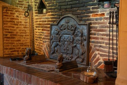 een muur met een plaquette op een bakstenen muur bij L'escapade d'Etretat in La Celle-sous-Gouzon