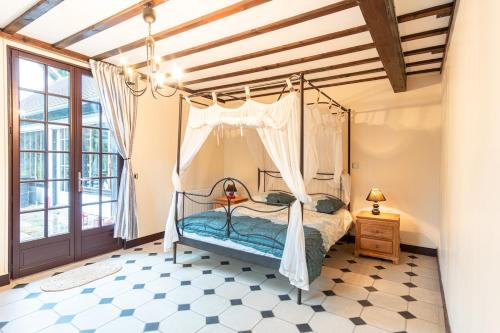 een slaapkamer met een hemelbed bij L'escapade d'Etretat in La Celle-sous-Gouzon