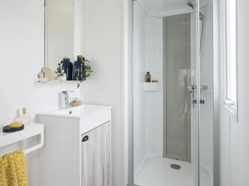 ein weißes Badezimmer mit Dusche und Waschbecken in der Unterkunft Camping 4 étoiles - Piscine - ccbegca in Créach-Guennou