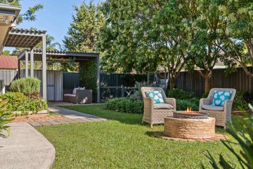 twee stoelen en een vuurplaats in een tuin bij Bliss at Jervis Bay - pet-friendly Vincentia home in Vincentia