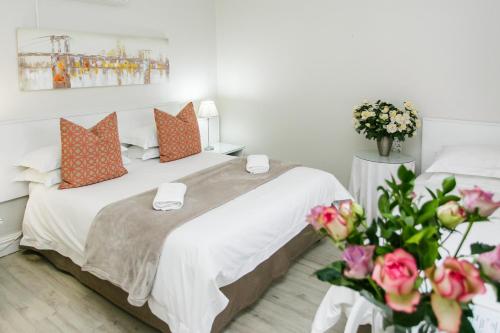 a bedroom with a bed with orange pillows and flowers at Wagon Wheel Country Lodge in Beaufort West