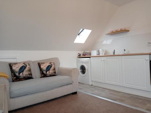 ein Wohnzimmer mit einem Sofa und einer Waschmaschine in der Unterkunft Hill View Studio in Hawick