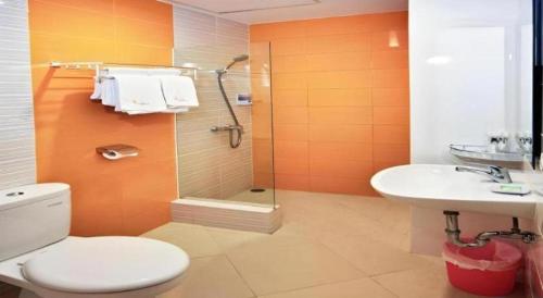 a bathroom with a toilet and a sink and a shower at Graha Cempaka Boutique Hotel in Surabaya