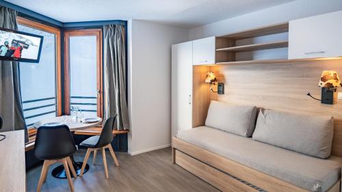 een hotelkamer met een bed en een bureau bij Résidence Odalys Tourotel in Val Thorens