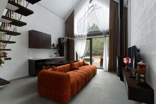 een woonkamer met een bank en een groot raam bij Нова Дача 