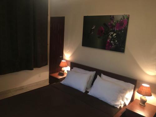 a bedroom with a bed with two lamps on two tables at The Balboa Inn in Panama City