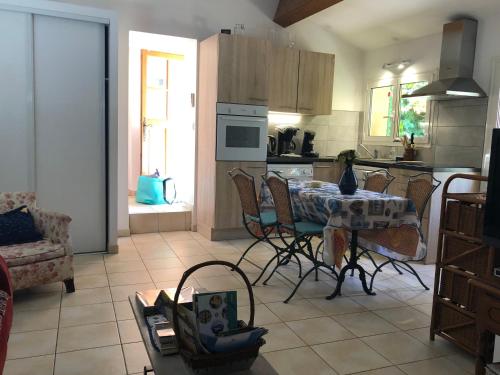 La Petite Maison في ساناري سور مير: مطبخ به طاولة وكراسي في غرفة