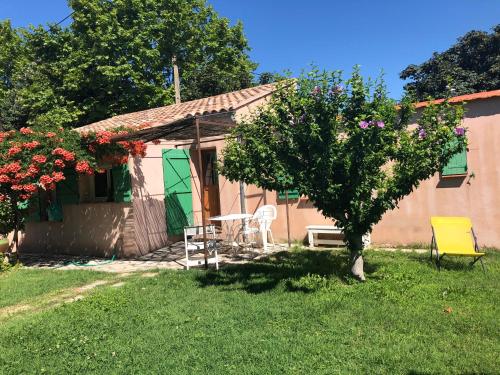 La Petite Maison في ساناري سور مير: منزل صغير به طاولة وكراسي في الفناء