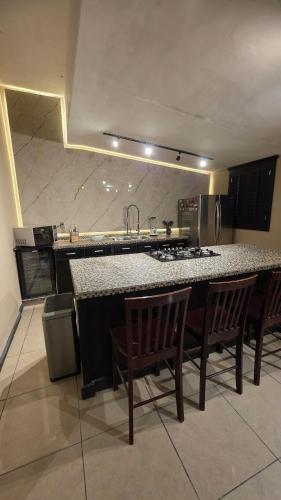 a kitchen with a counter and chairs and a counter top at Luxury Suites Seoul Consulado in Zaragoza