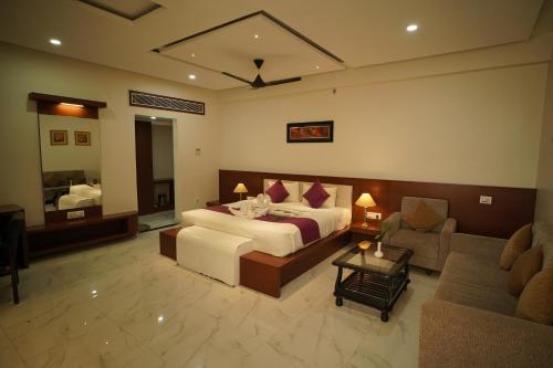 een slaapkamer met een bed en een woonkamer met een bank bij Mount Valley Resort in Kumbhalgarh