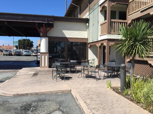 a patio area with chairs, tables, and umbrellas at Vagabond Inn Executive SFO in Burlingame