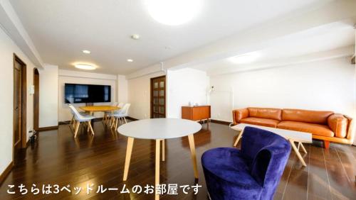 a living room with a couch and a table and chairs at ベルビー川崎 - 川崎駅から徒歩圏 - 羽田空港からのアクセス良好 in Kawasaki