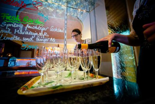 a person pouring wine into wine glasses on a counter at Holzschuhs Schwarzwaldhotel in Baiersbronn