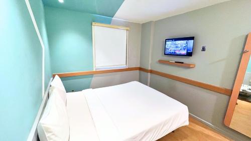 a hospital room with a bed and a flat screen tv at Ibis Budget Jakarta Airport in Tangerang