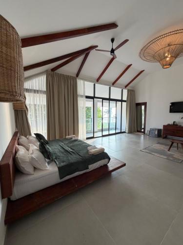 a bedroom with a bed in a room with windows at Shoonya - A Boutique Stay in Varkala