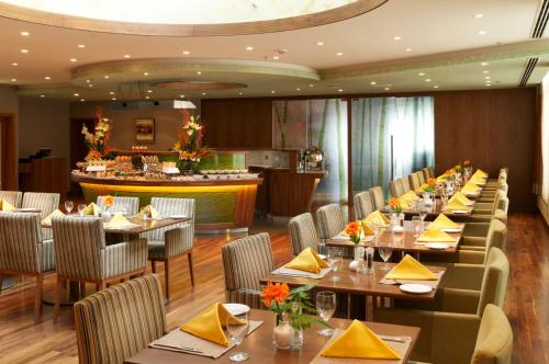a restaurant with tables and chairs and a bar at Montreal Barsha Hotel in Dubai