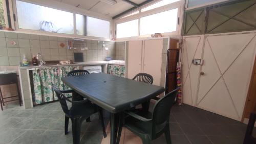 eine Küche mit Tisch und Stühlen in einem Zimmer in der Unterkunft La Casa del Ferroviere in Letojanni