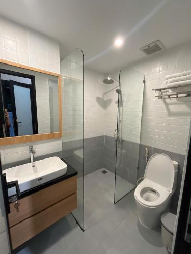a bathroom with a sink and a toilet and a mirror at Madam Thu House in Hue