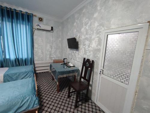 a bedroom with a desk and a bed and a window at ASR HOSTEl in Andizhan