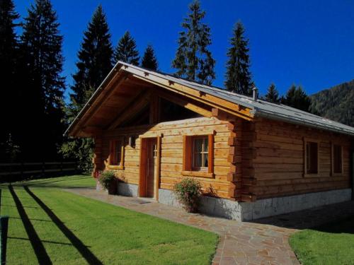 una piccola cabina in legno con un prato di Chalet Eco-Lodge Faè a Madonna di Campiglio